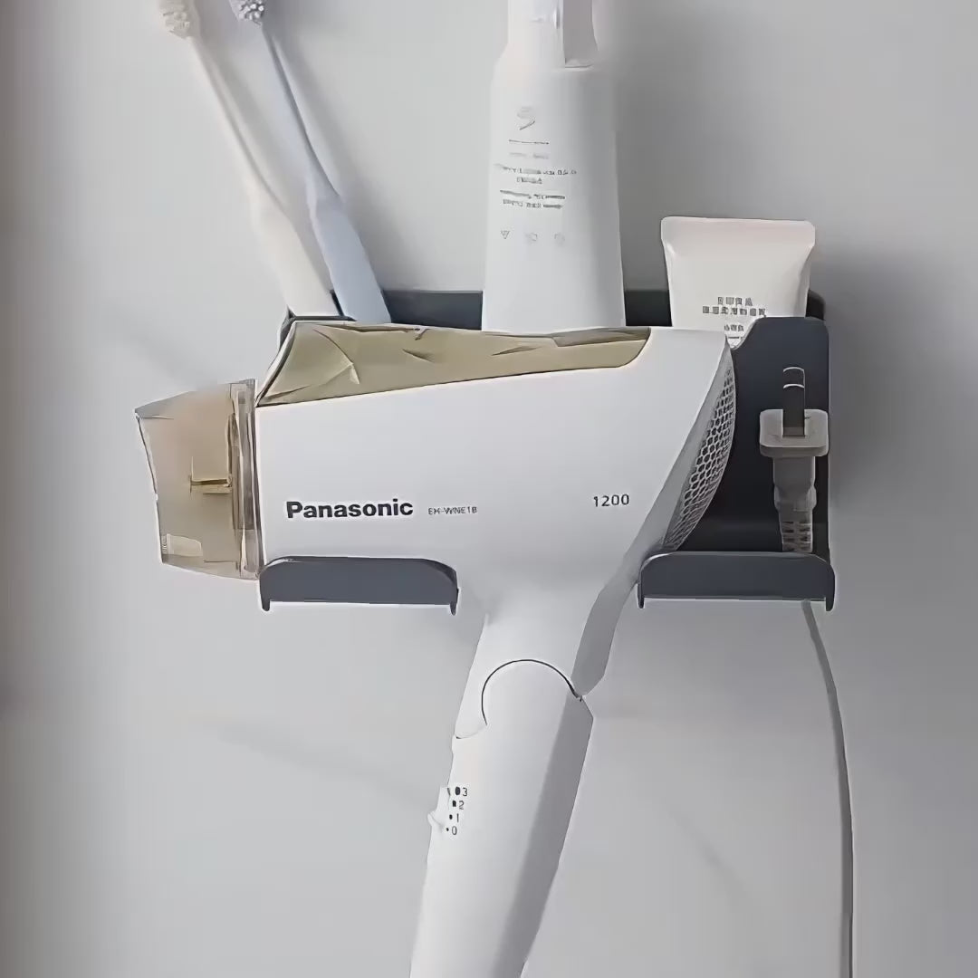 Black wall-mounted DryDock hair dryer holder holding a corded hair dryer